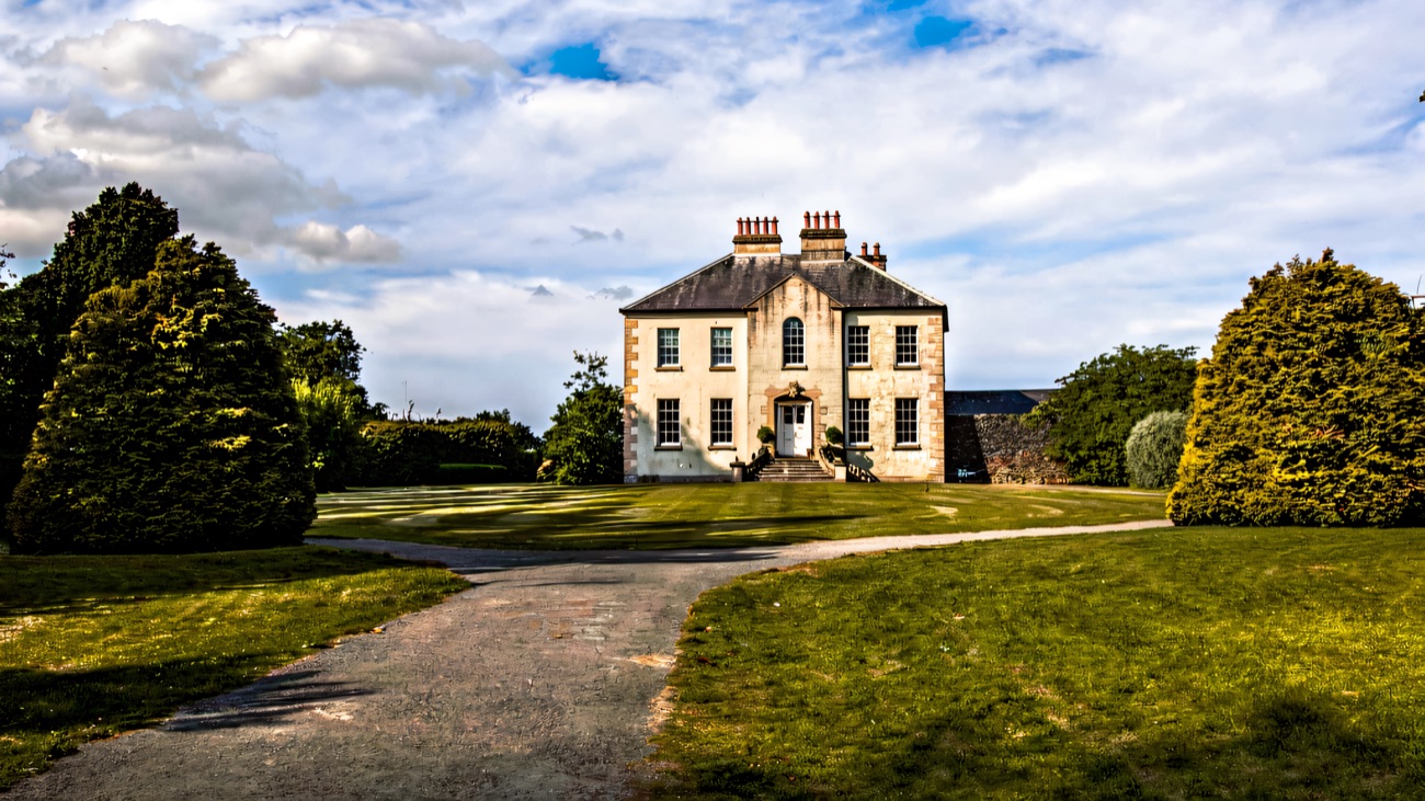 Gracehill House, a grey-stone Georgian house at the end of a gravel drive under a blue sky