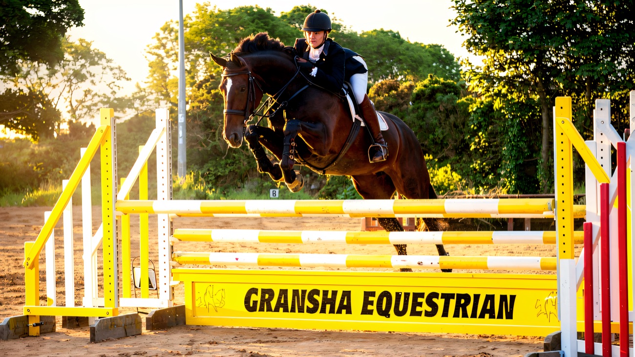 A horse and rider jumping the centre's own branded fence