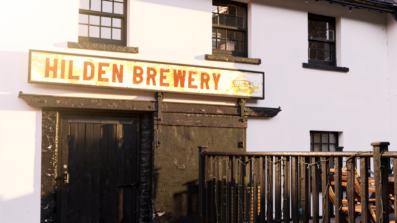 The old painted Hilden Brewery sign above a black door on the whitewashed building