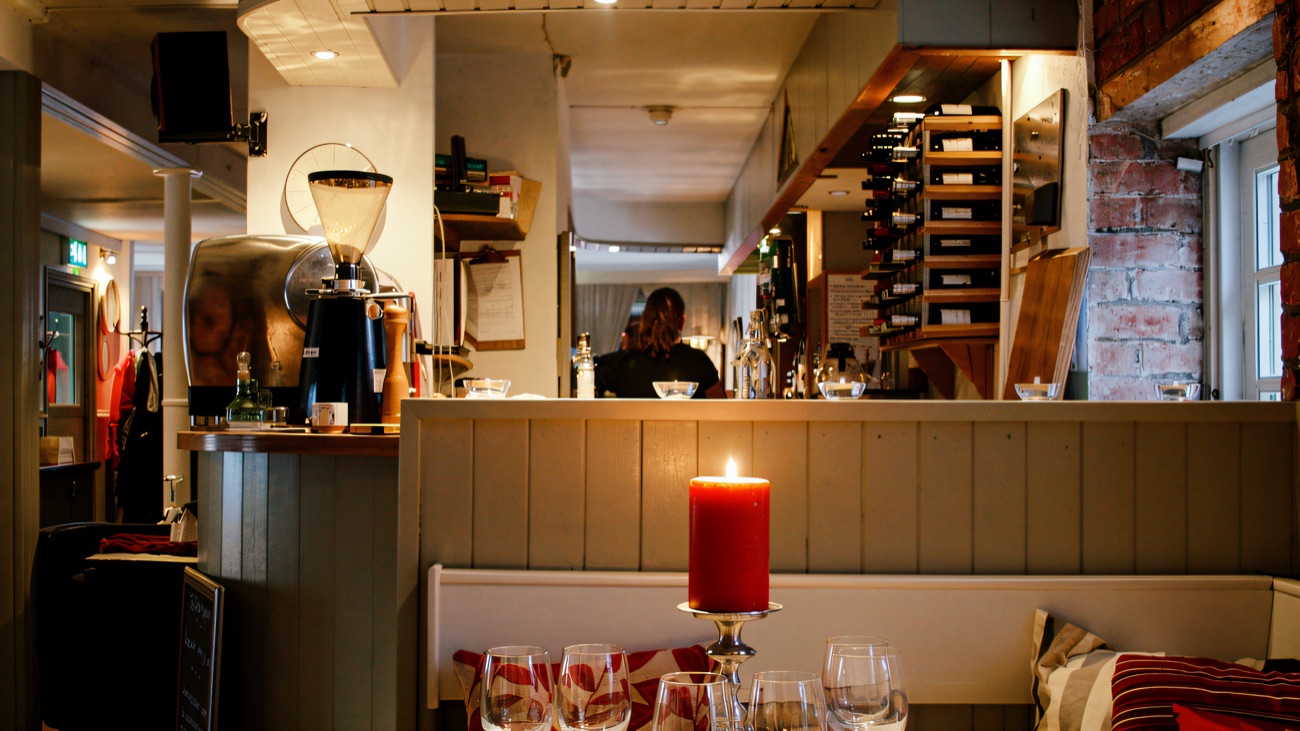 The restaurant with a candlelit table laid for dinner and exposed brick walls