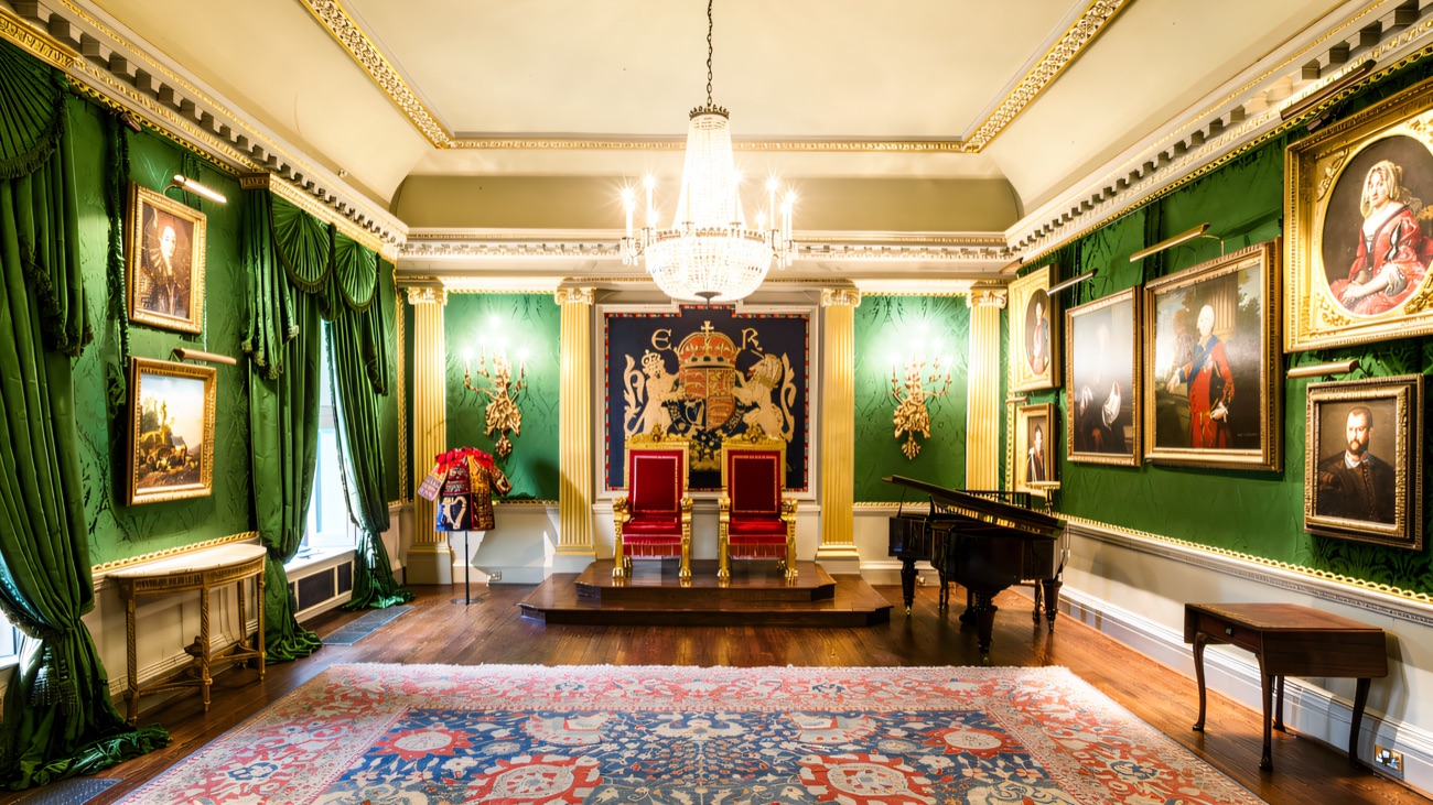 The Throne Room inside Hillsborough Castle, red-and-gold thrones under a chandelier in a green-walled state room