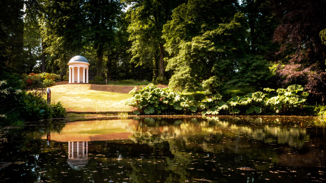 A domed classical temple reflected in the still lake in the Hillsborough Castle grounds