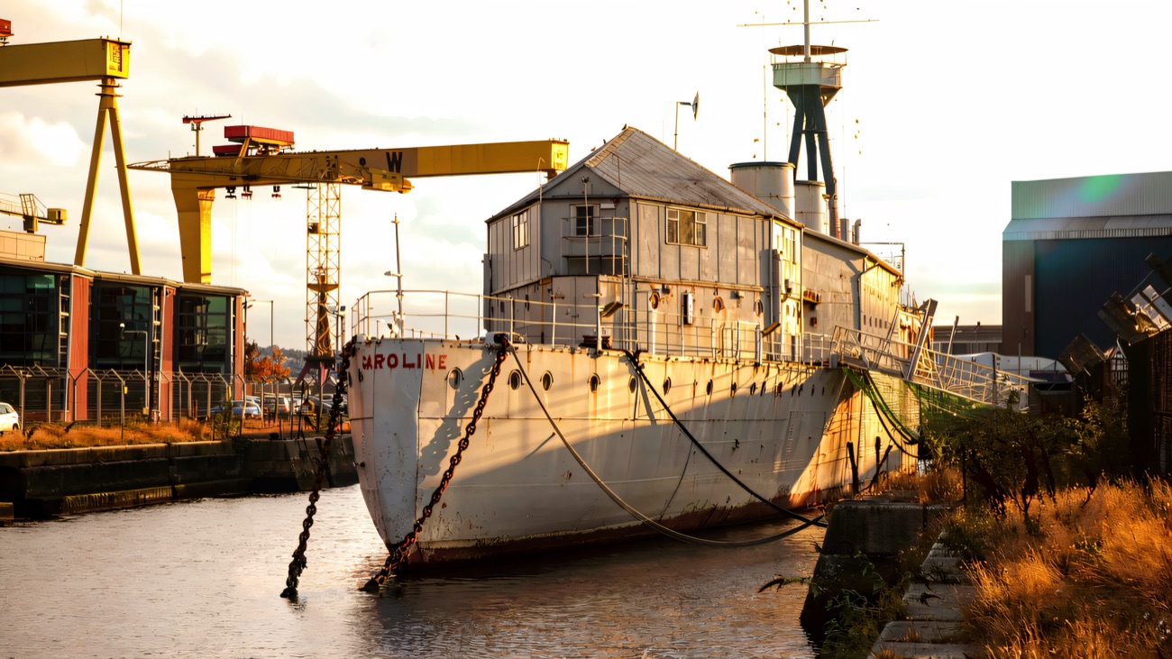 The WWI light cruiser at her berth in Belfast, with the Harland and Wolff cranes behind.