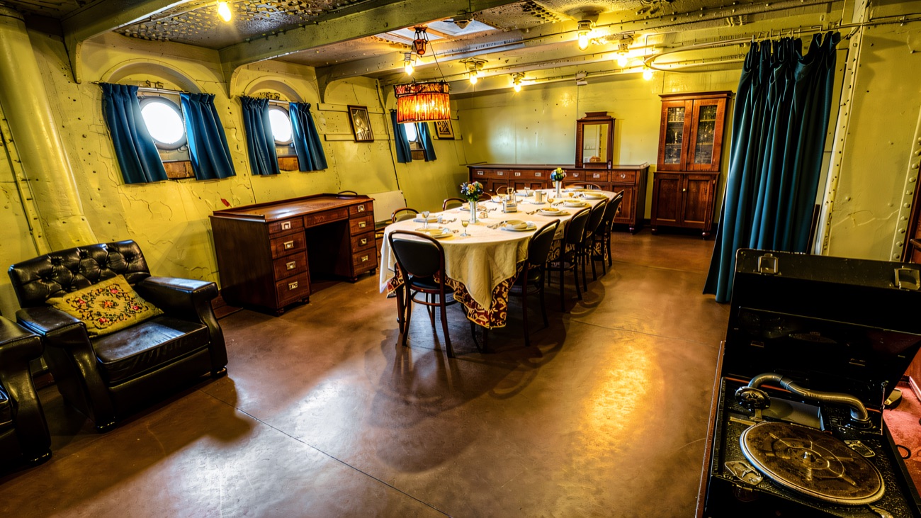 The restored officers' wardroom, laid out with its gramophone and dining table.