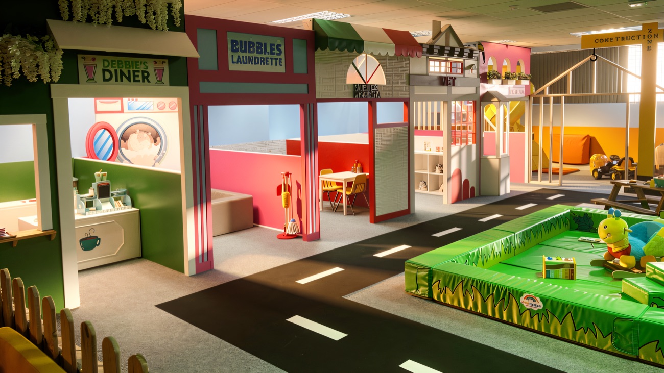 The role-play street with a pretend diner, launderette, pizzeria and vet, beside a padded toddler mat