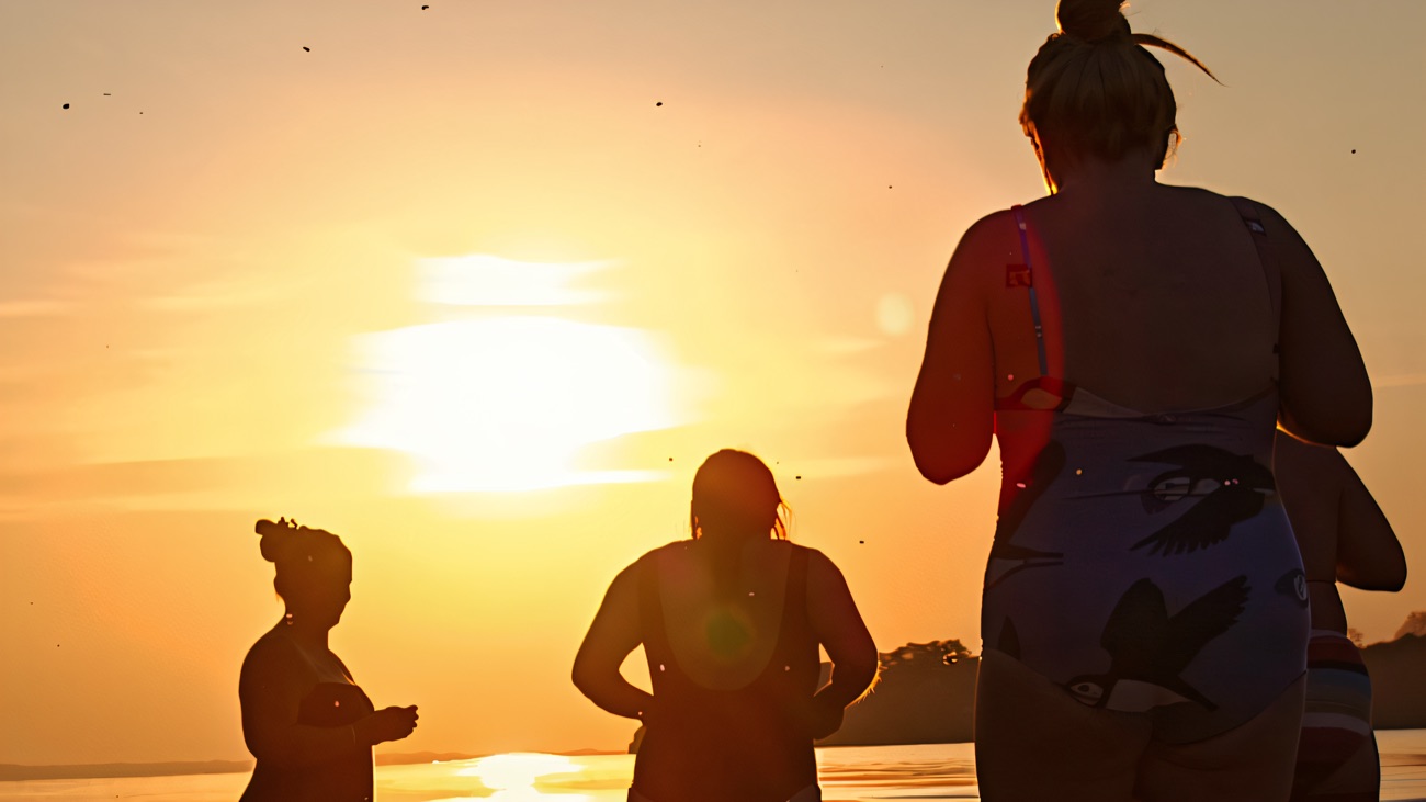Bathers silhouetted in the lough at last light