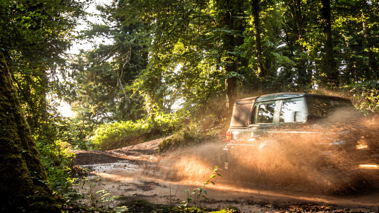Mud flies as a 4x4 attacks a forest trail