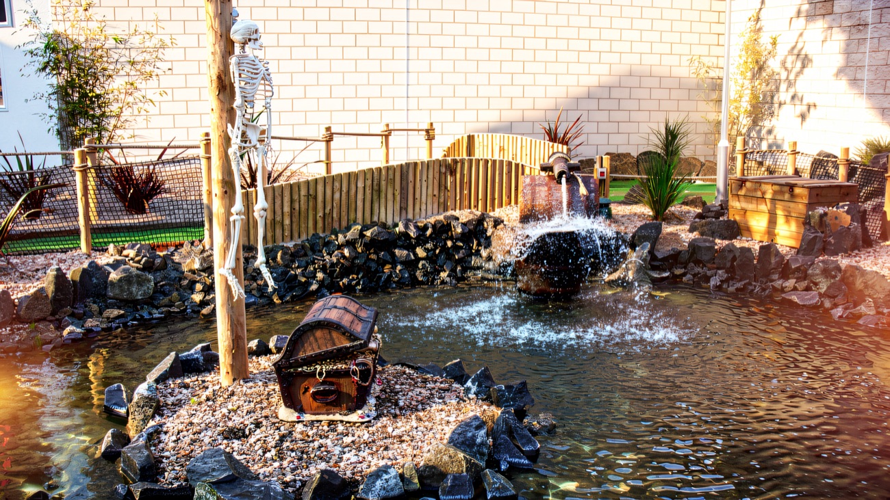 The skeleton and treasure-chest water feature on the course