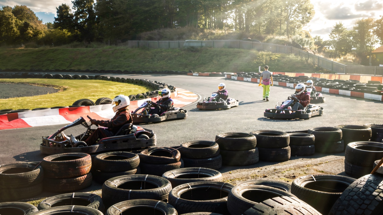 Helmeted drivers racing round the track on a bright day