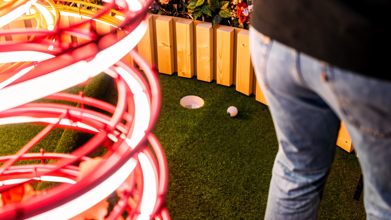 A neon-spiral hole set among the flowerbeds at Kaboodle's botanical indoor mini golf in Derry