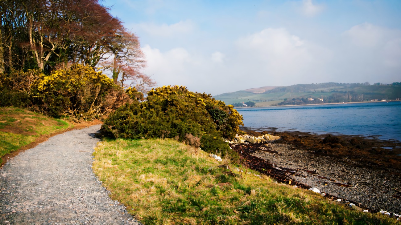 The gravel shore path winding along the water's edge