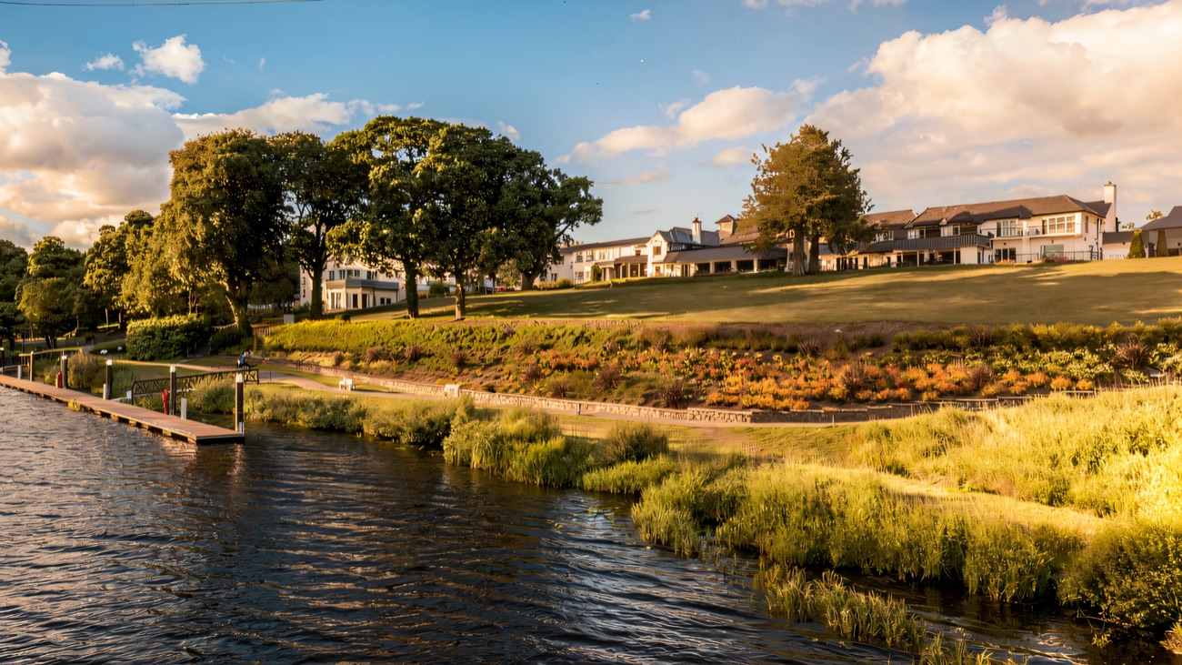The hotel's lakeside gardens with bright flowerbeds running along the shore of Lough Erne