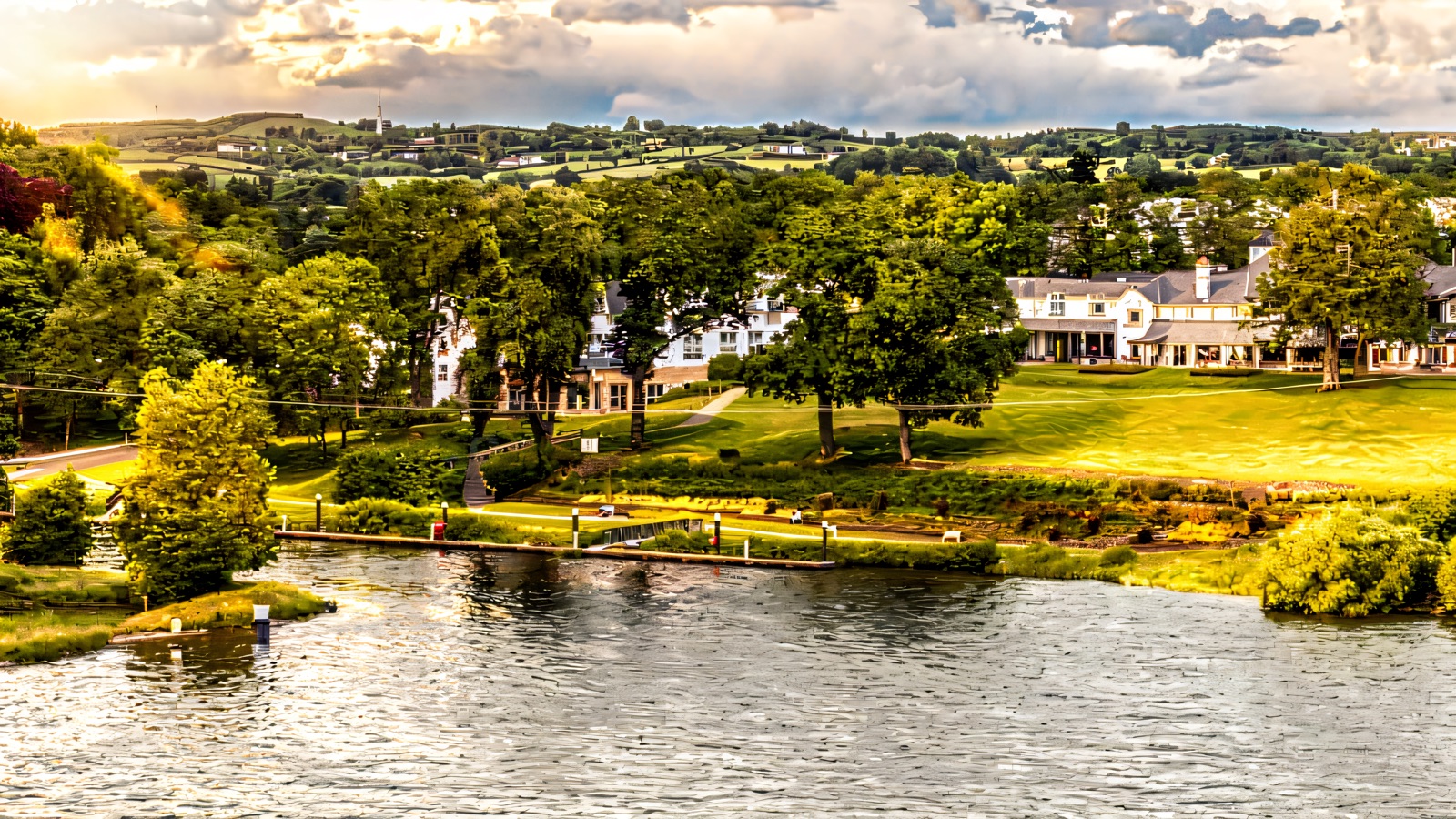 An aerial view of Killyhevlin Lakeside Hotel spread along the green shore of Lough Erne, with gardens, a jetty and the water in front