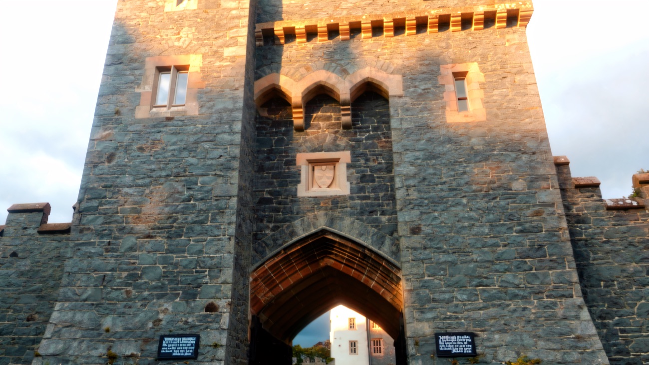 The crenellated stone gatehouse arch of Killyleagh Castle, the house glimpsed through the gate