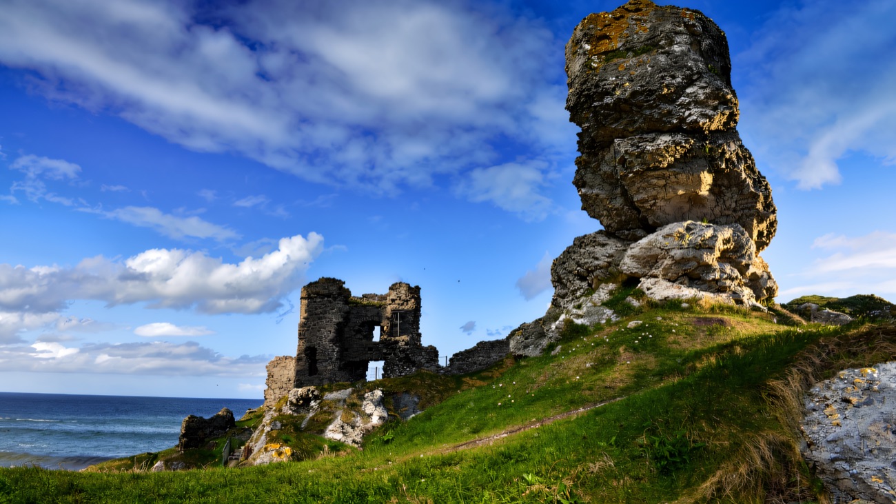 The broken walls beside the great white limestone stack under a blue sky.