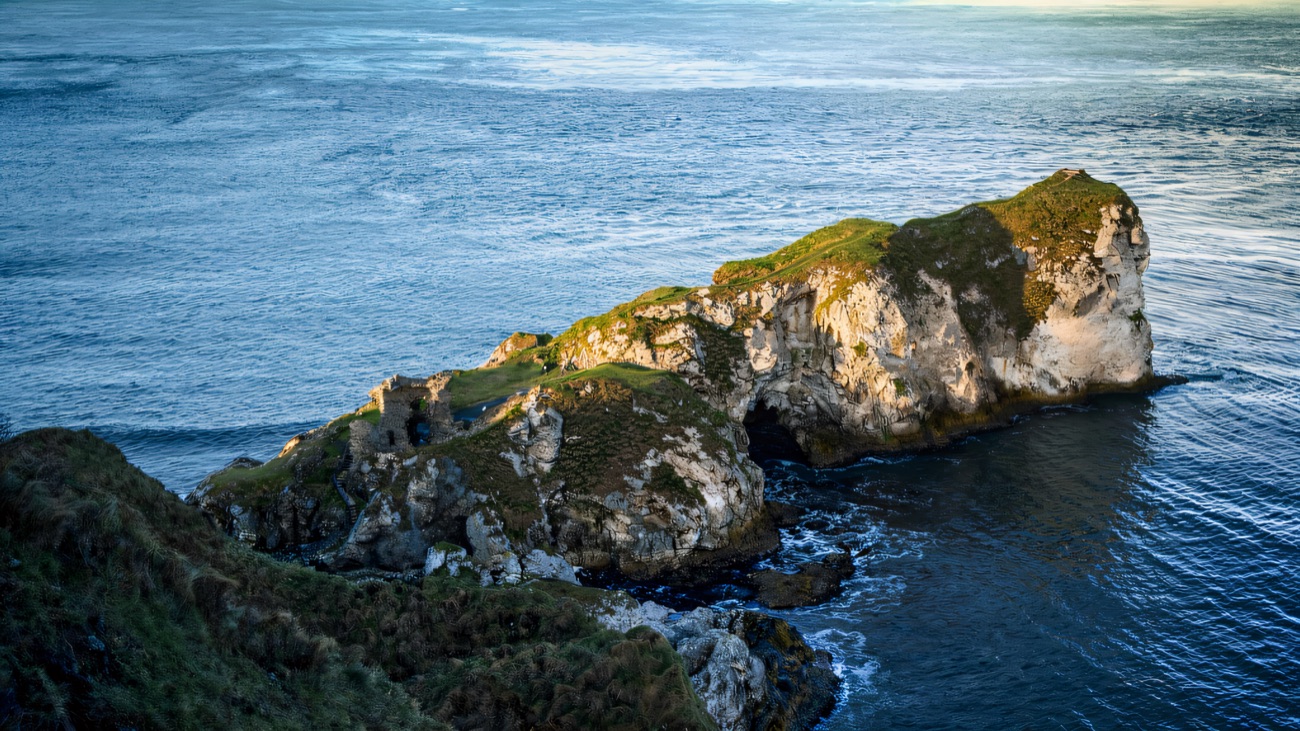 The castle rock seen from above, ringed by open water.