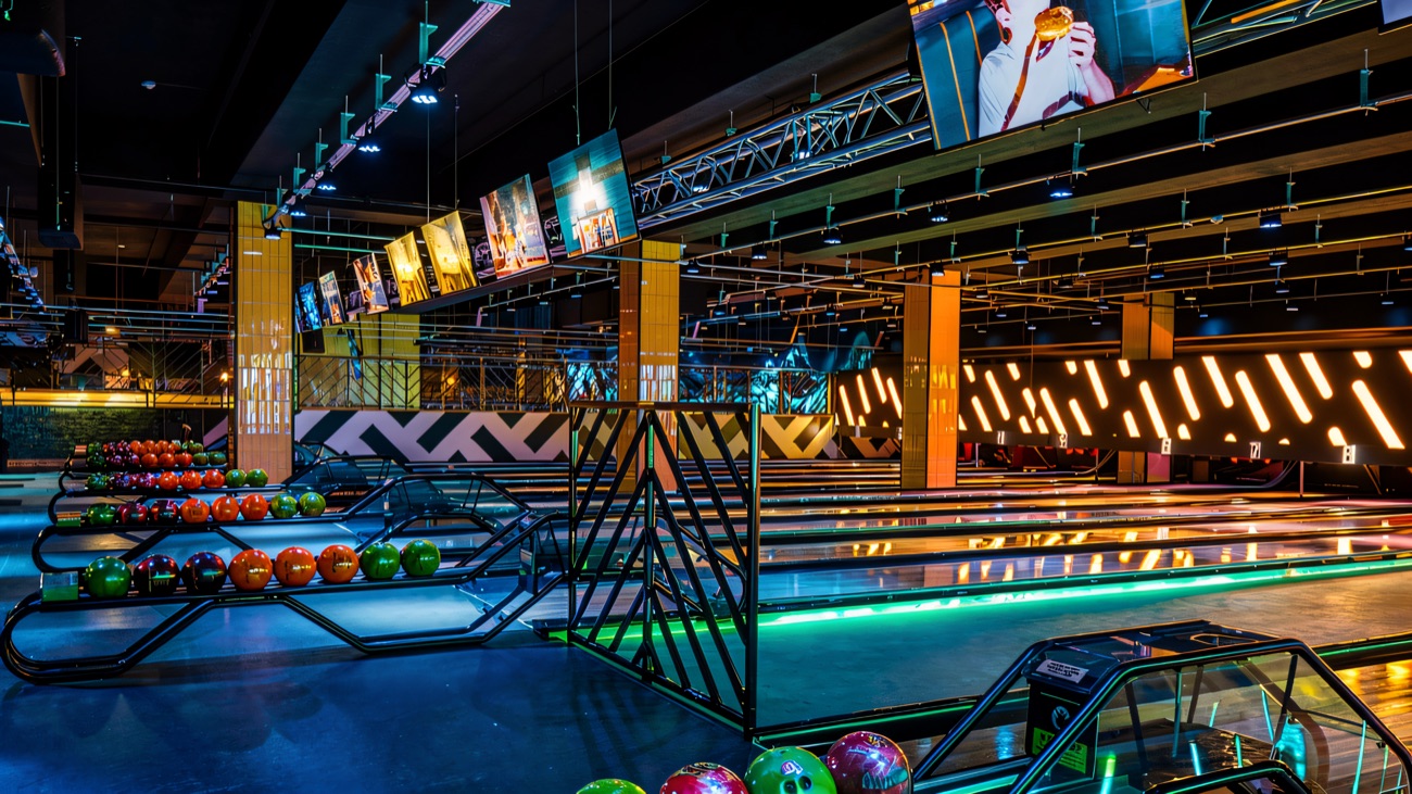 Bright, colourful lanes with ball racks and score screens ready to go