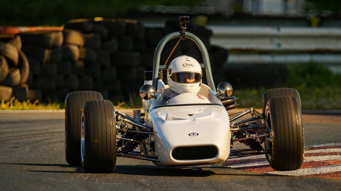 A classic single-seater sweeps past the tyre wall