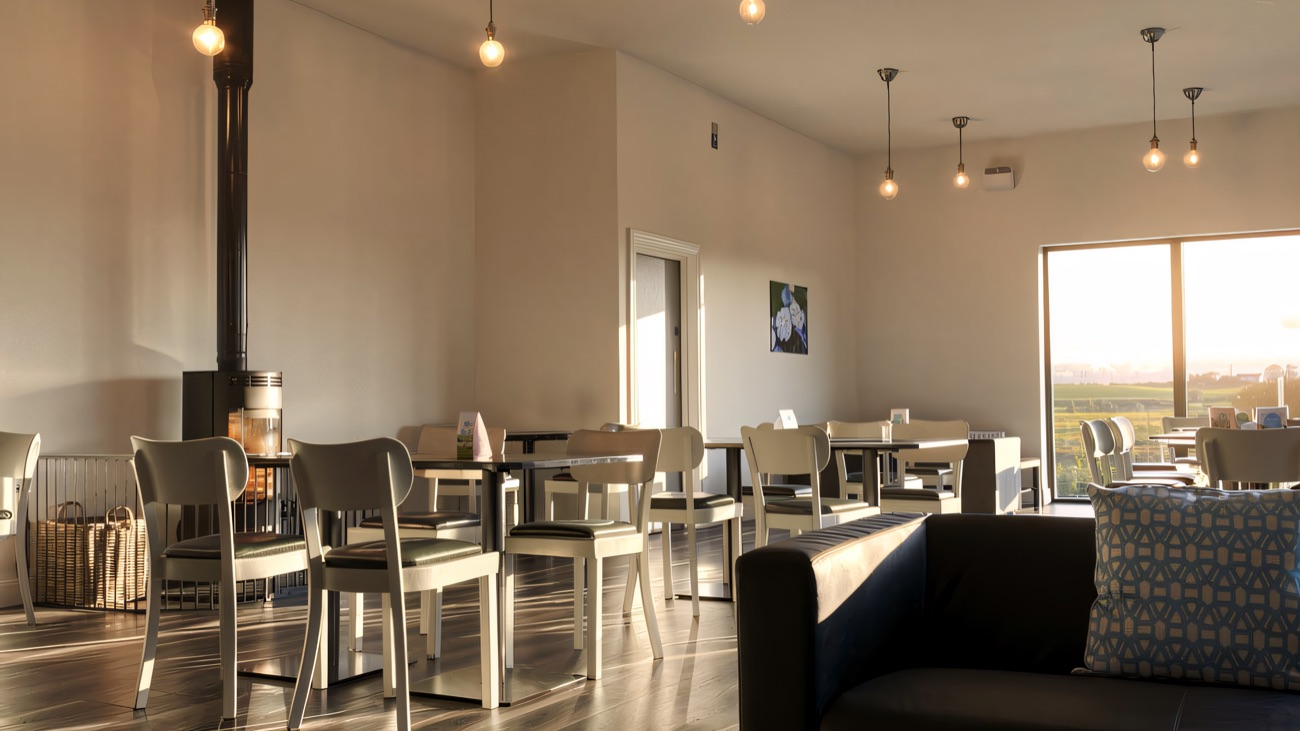 The bright tearoom with a wood-burning stove and countryside views through the window