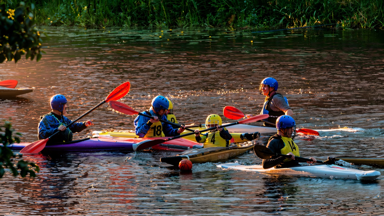 Kayaks jostling in a fast-paced game of canoe polo