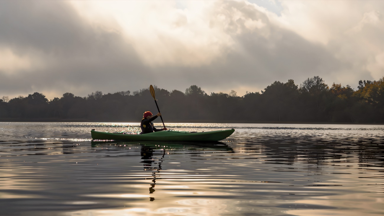 A lone paddler on a mirror-calm, misty Lough Erne