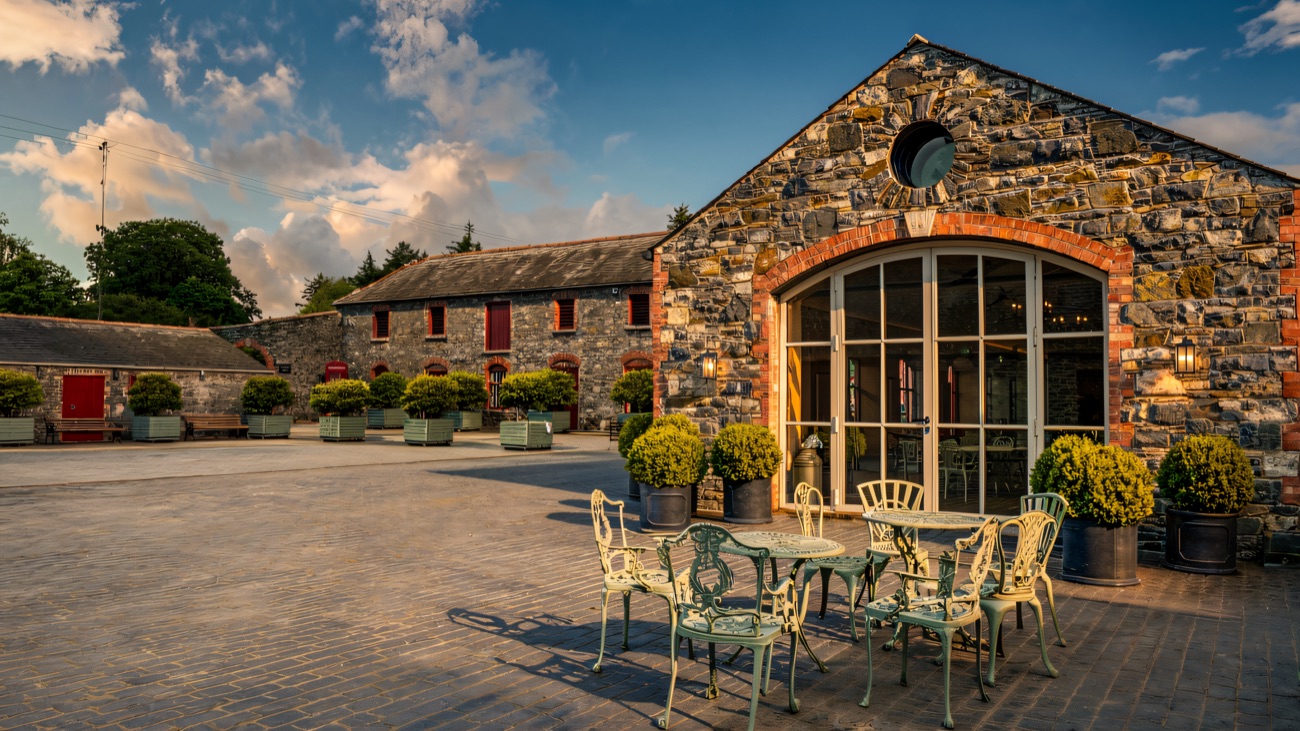 The cobbled courtyard and stone barn with its tall arched glass doors