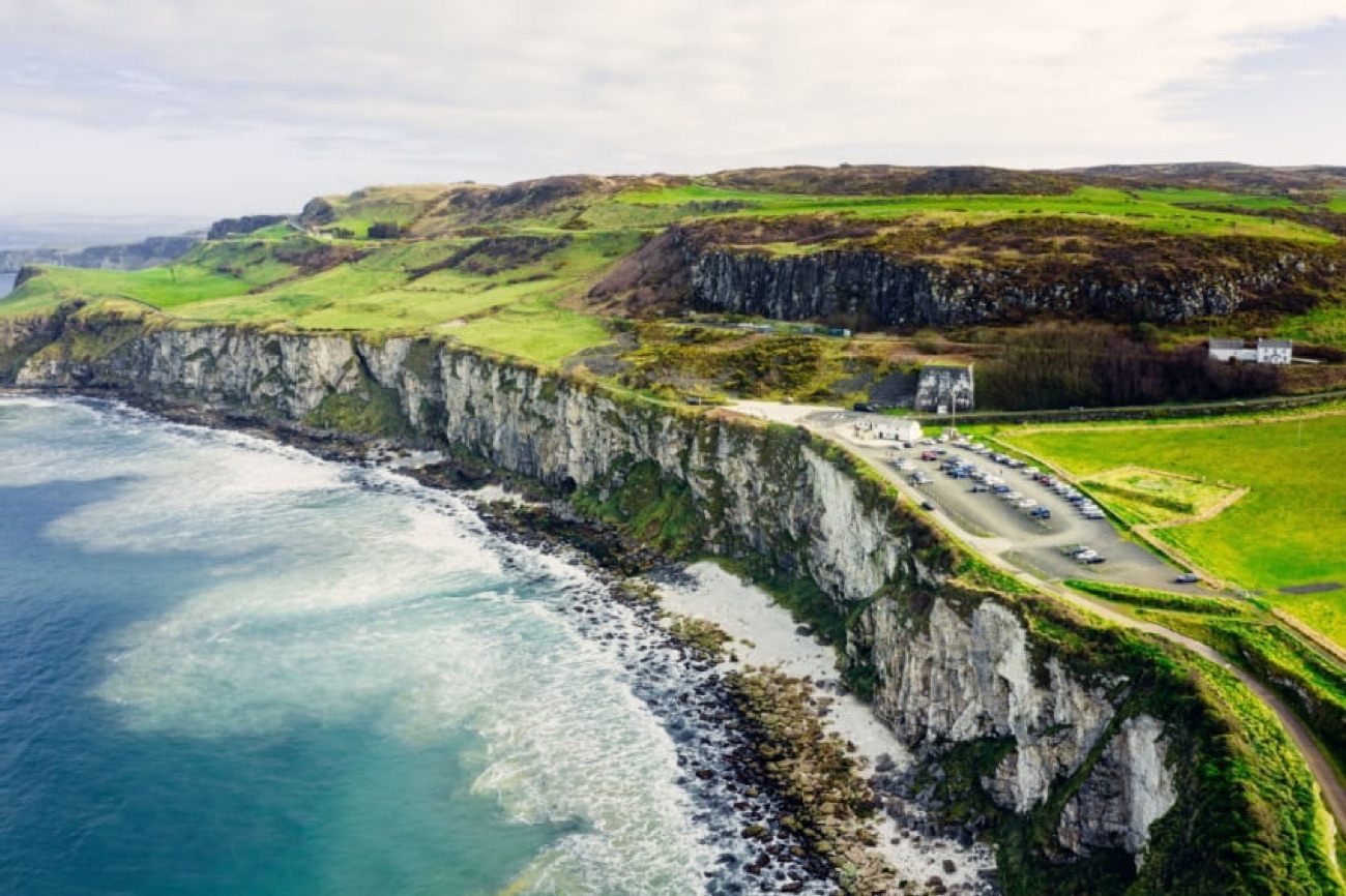 Aerial view of the white Larrybane cliffs, the headland and its car park on the Causeway Coast