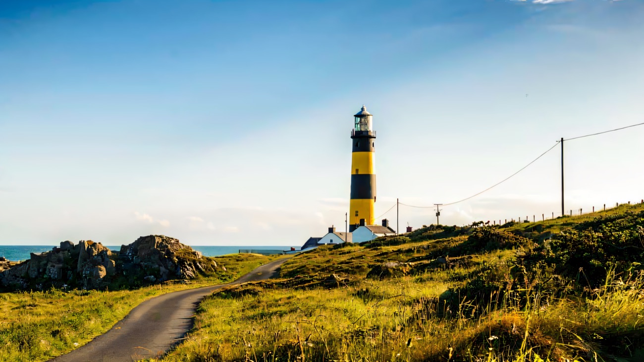 The black-and-yellow St John's Point lighthouse, the path leading up to it
