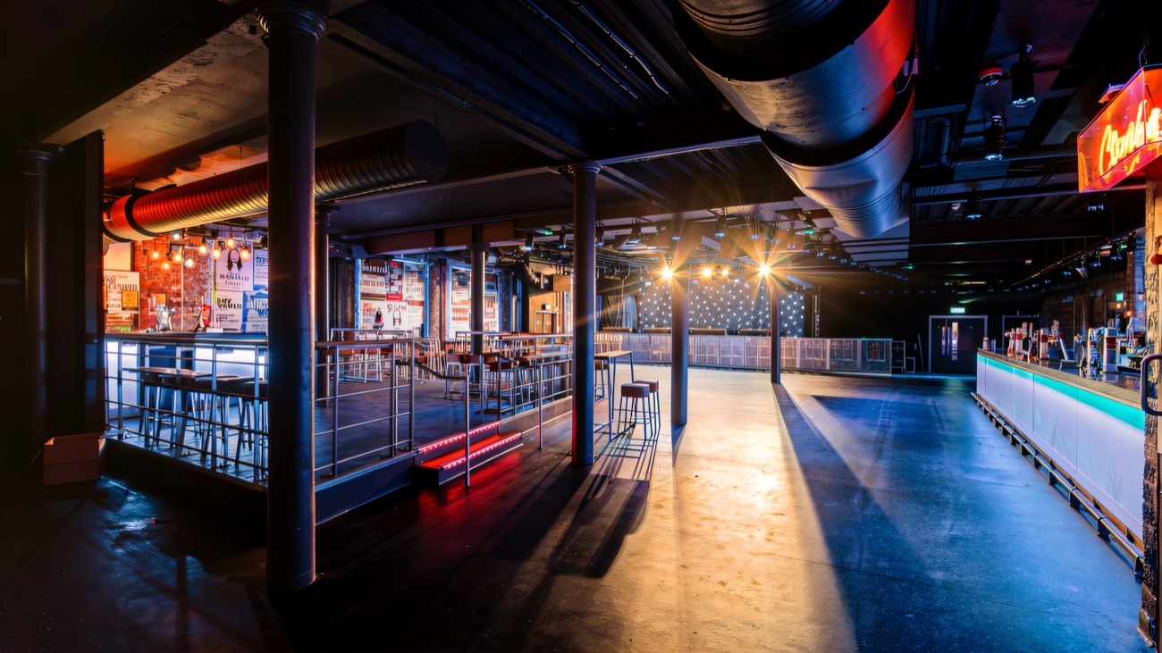 The empty venue floor in blue light, looking towards the stage