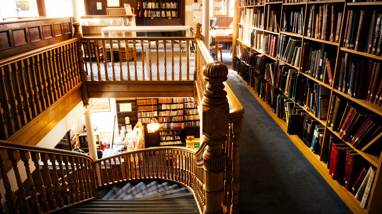 The handsome timber staircase winding past the library's book stacks