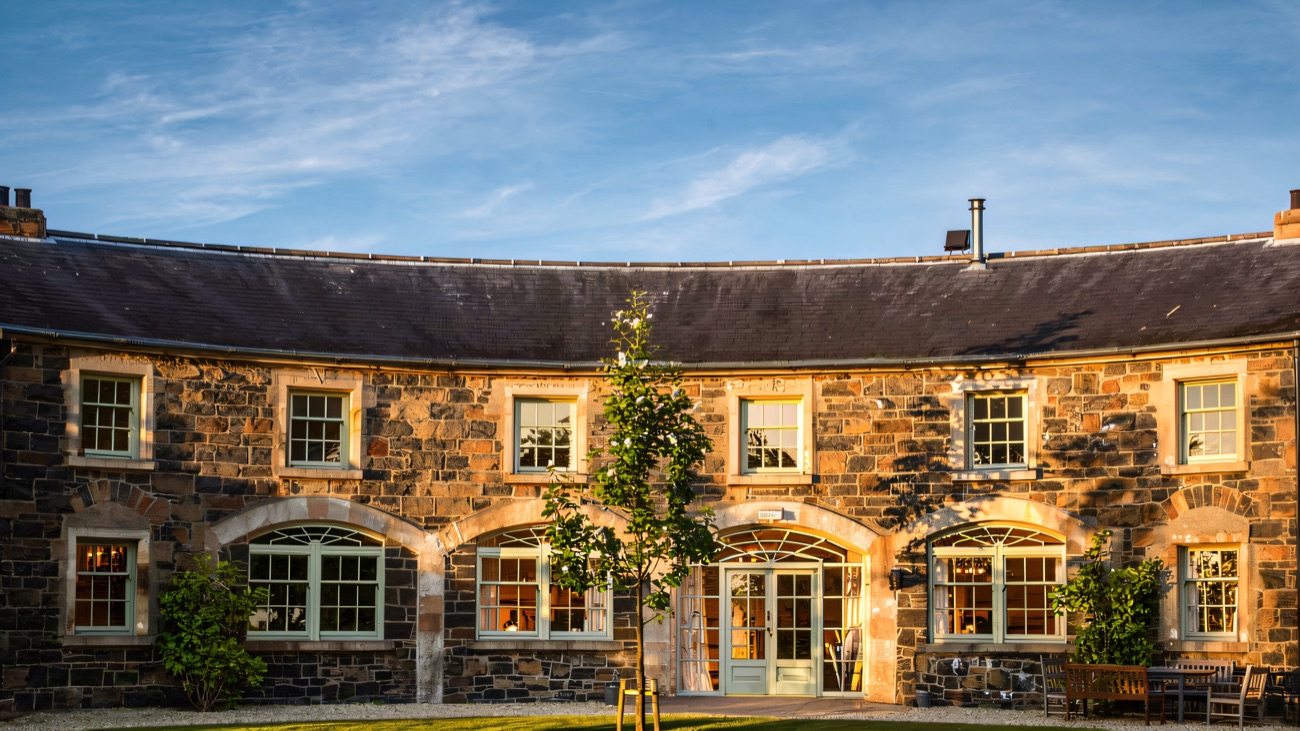 The restored curved coach-house courtyard in stone, with tall arched windows