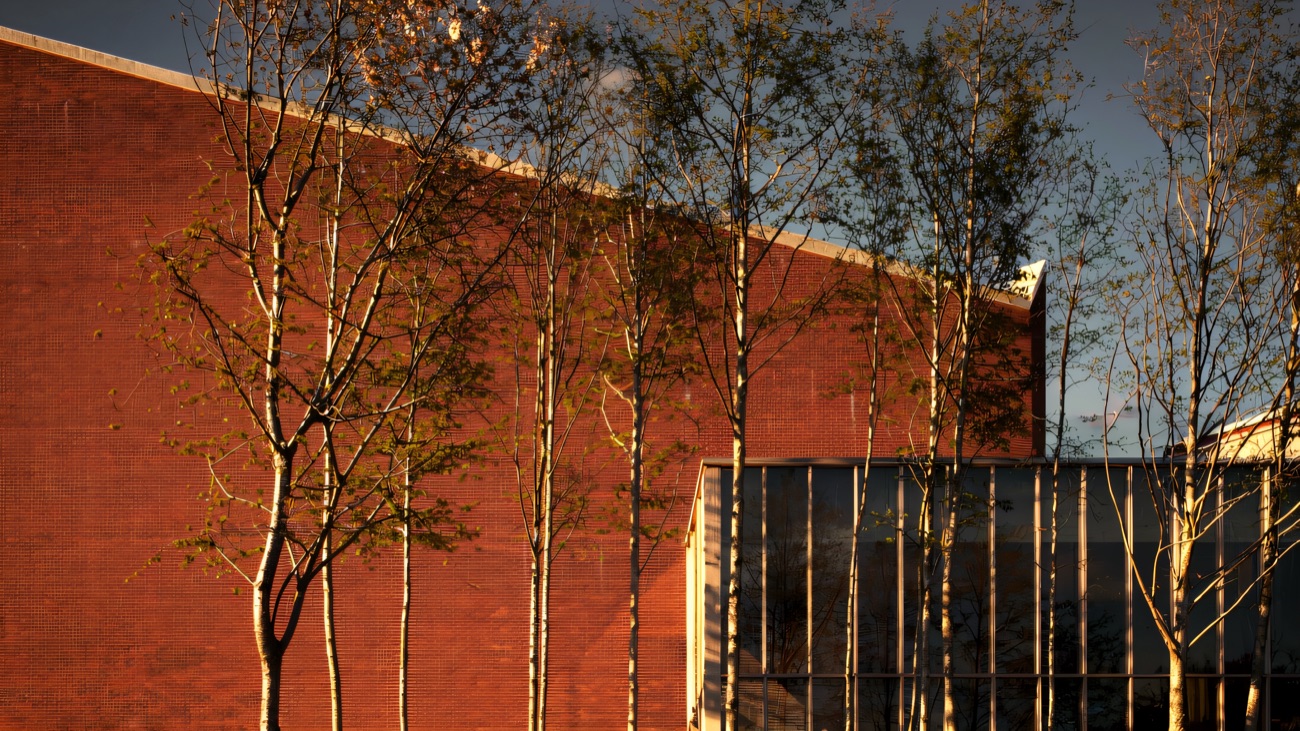 The red-brick entrance under the trees