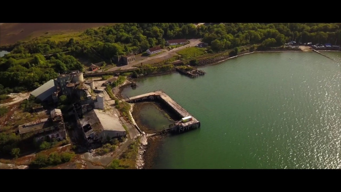The old quarry works and pier reaching out into the green waters of Larne Lough