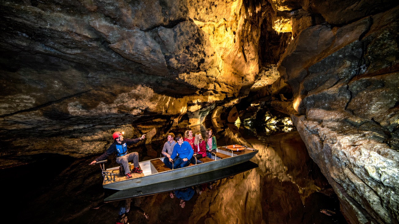 The underground boat tour glides beneath a glowing limestone roof
