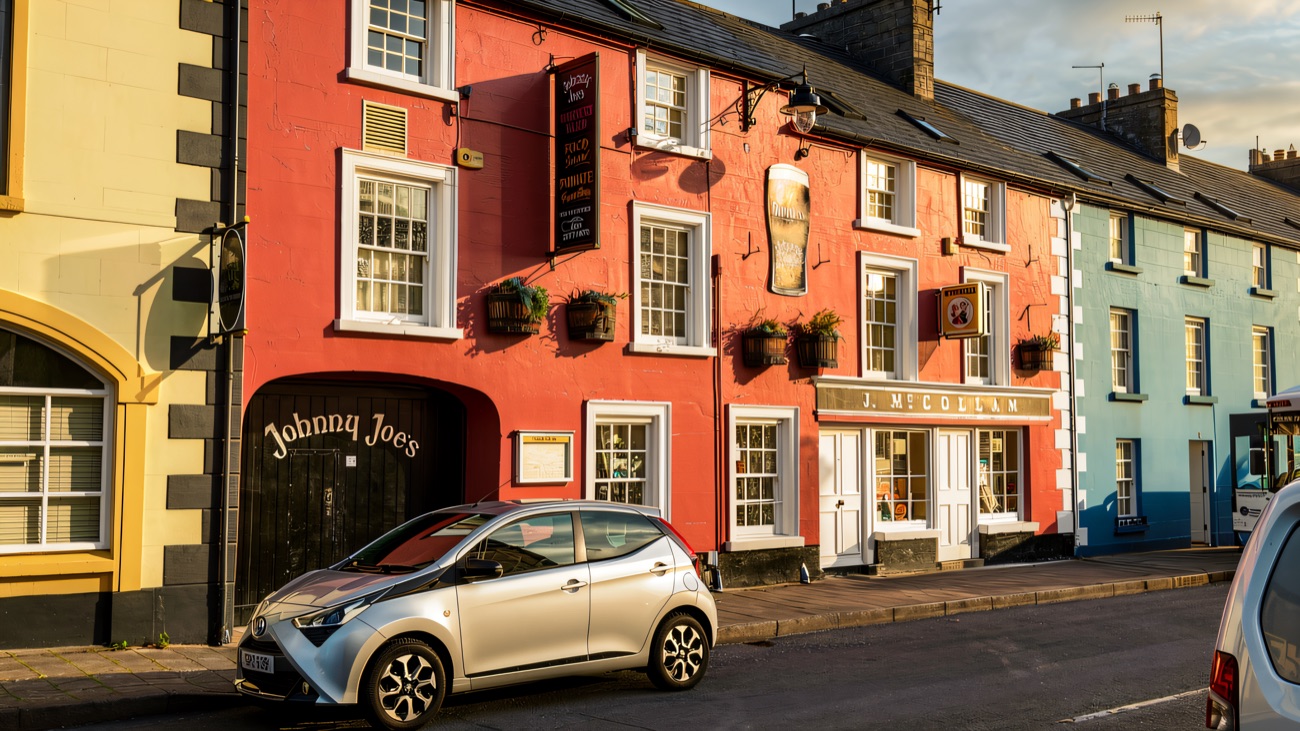 The bright pink frontage on the village street, with the Johnny Joes archway and the J. McCollam signboard