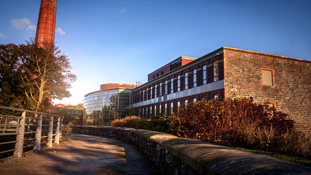 The riverside walkway leading up to the mill's glass entrance pavilion