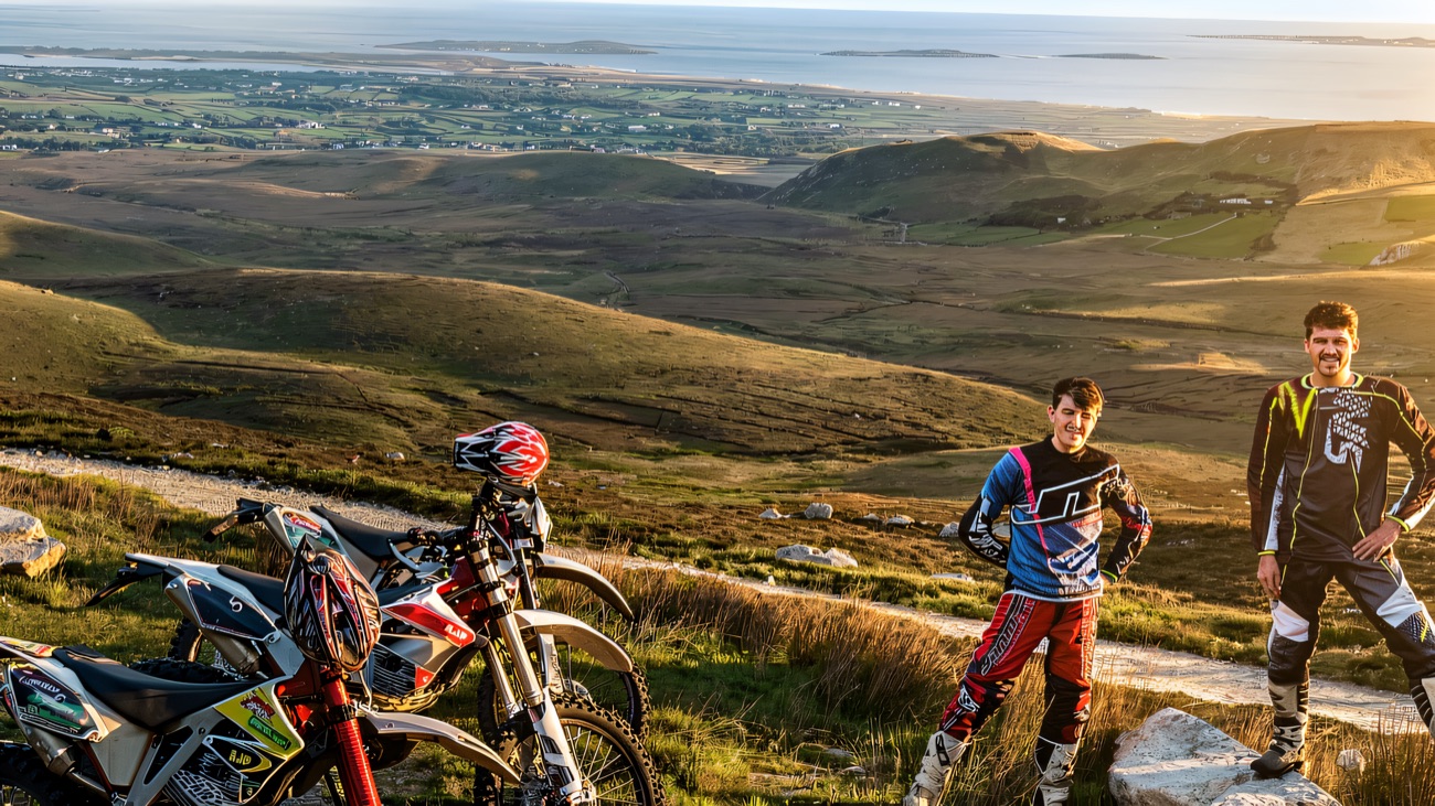 Riders take a breather on a mountain trail with sweeping views over the coast