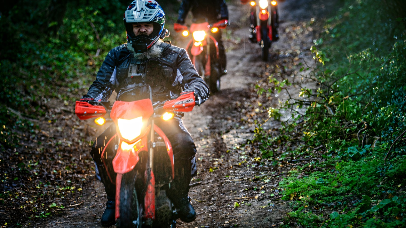 A group riding through a leafy off-road lane