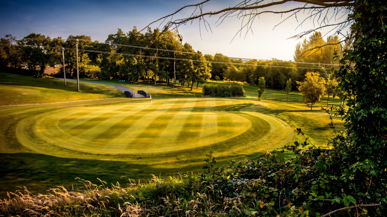 Neatly striped fairways sweep through the wooded parkland course