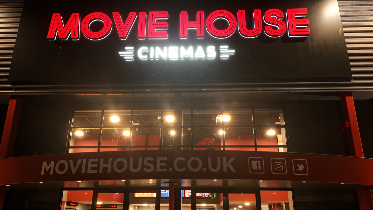 The lit Movie House sign at night