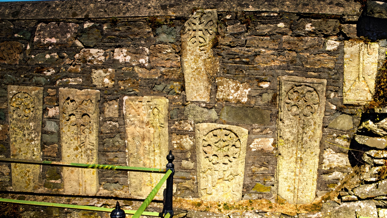 Medieval cross-carved grave slabs set into the old abbey wall.