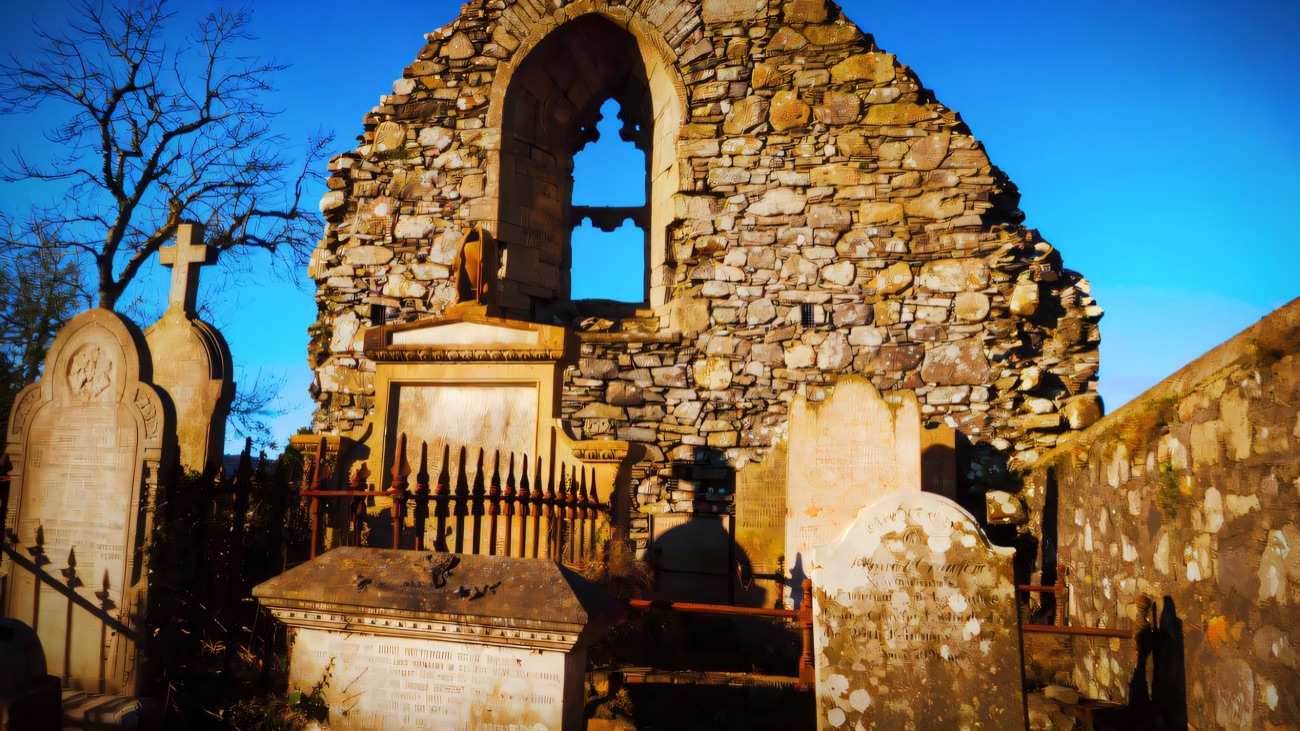 The gable end with its slim tracery window, framed against a blue sky.