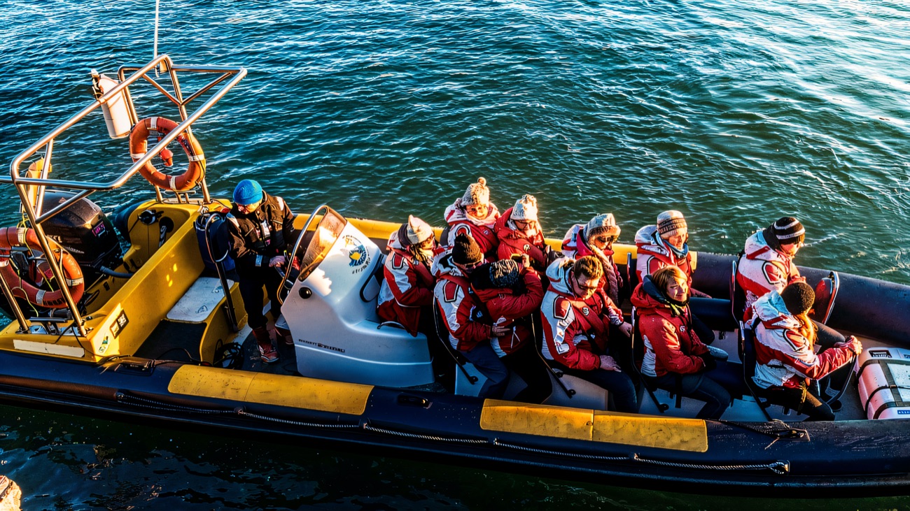 Kitted-out passengers settle aboard the yellow RIB before the trip out