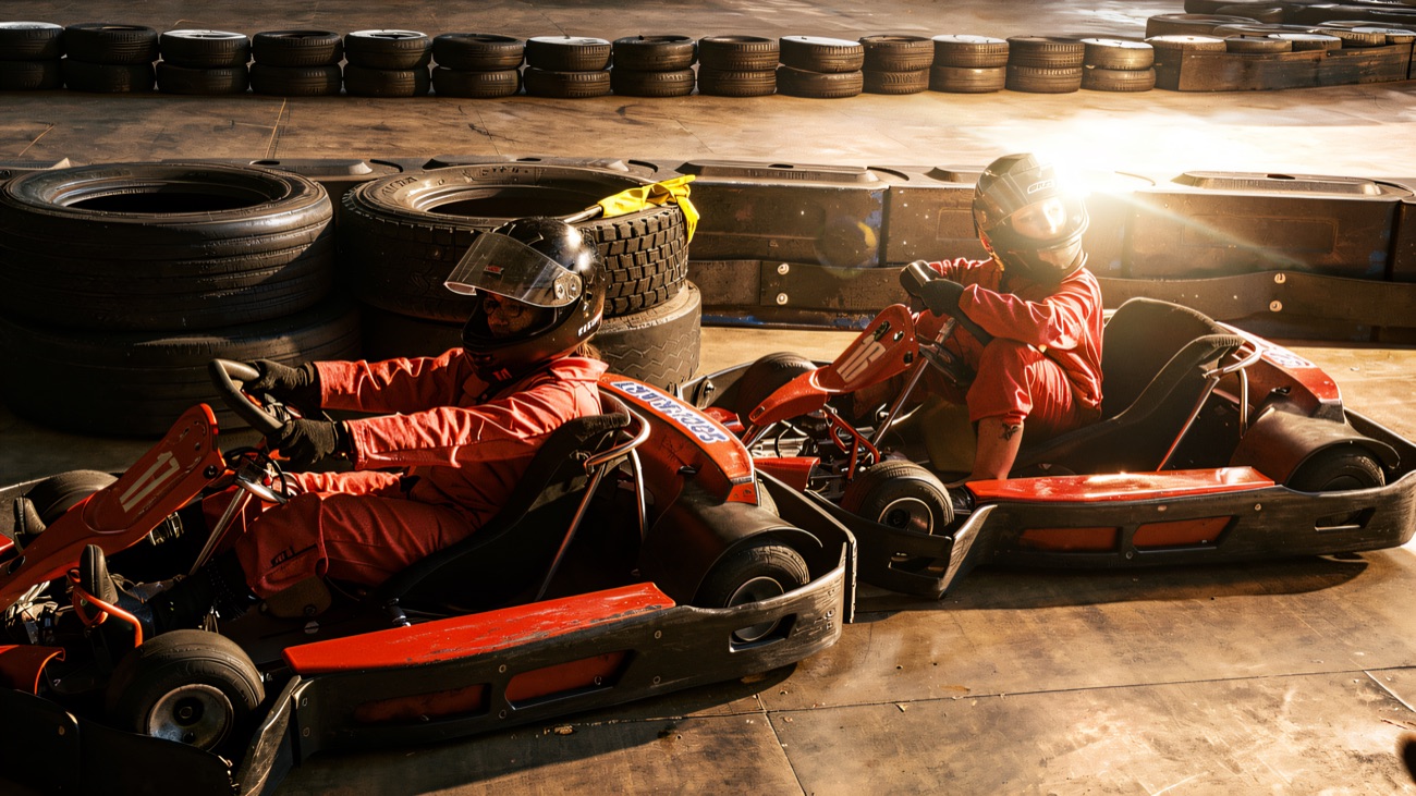 Helmeted drivers side by side on the indoor kart circuit