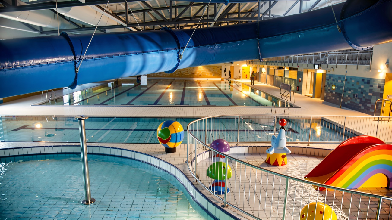 Wide view across the main pool hall with the flume running down one side
