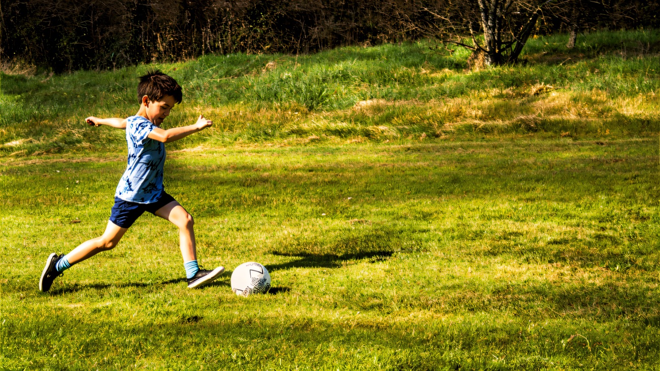 Striking the ball across the grass course on a bright day
