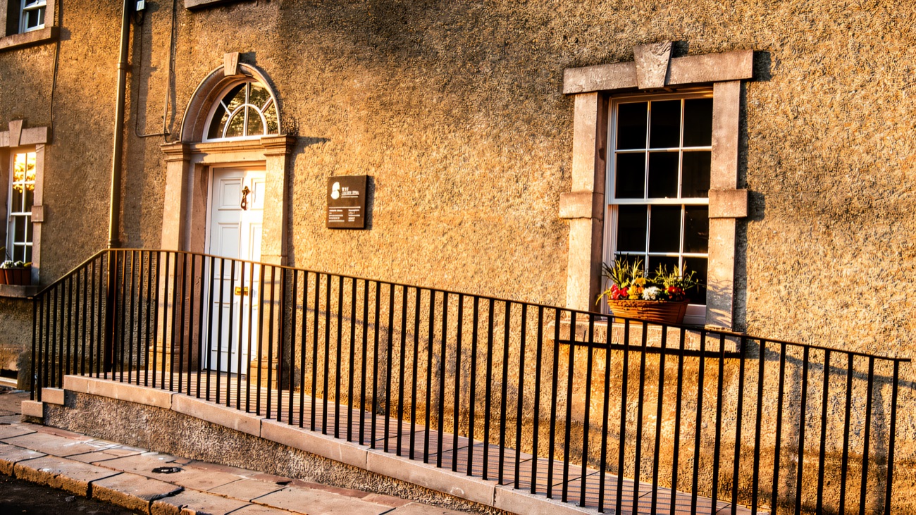 A closer look at the No. 5 door and its curved fanlight above the plain stone step.