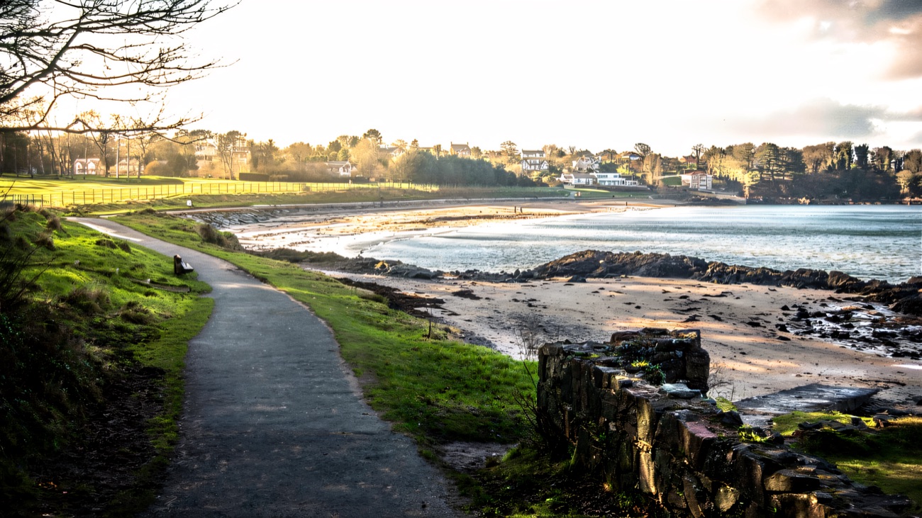 A quiet stretch of the walkway hugging a sandy bay