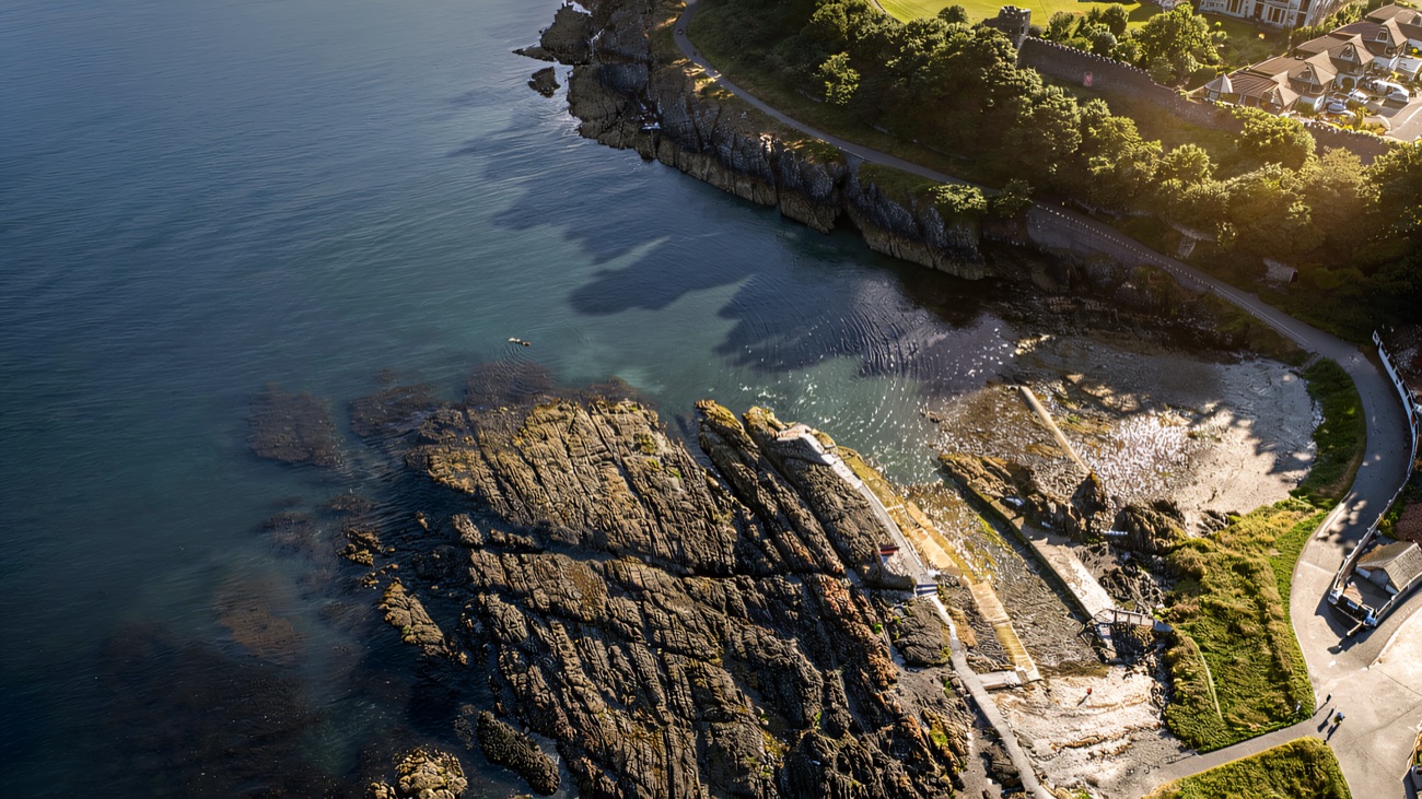 An aerial view of the rocky coastline the path traces