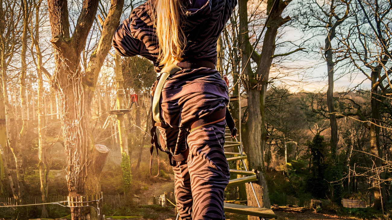Balancing up a rope ladder deep in the woods